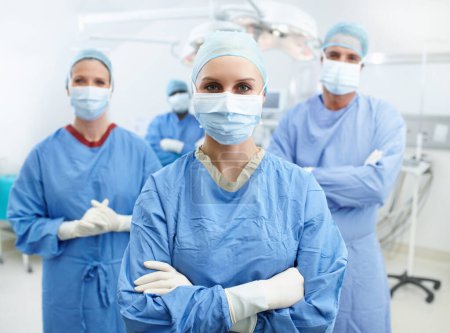 Foto de Confía en nosotros con tu vida. Grupo de cirujanos que usan uniformes hospitalarios, mascarillas y guantes protectores en una sala de emergencias - Imagen libre de derechos