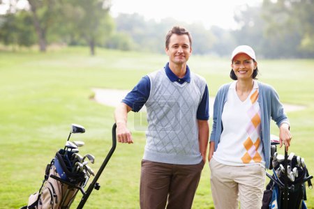 Téléchargez les photos : Couple souriant sur le terrain de golf. Portrait de couple debout sur un terrain de golf et souriant - en image libre de droit