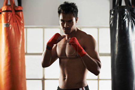 Hes dedicated to the sport of boxing. a young male boxer in a fighting stance