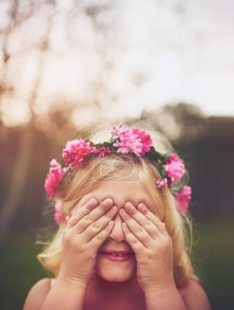 Foto de Soy invisible. una niña alegre con las manos en los ojos jugando a las escondidas en la naturaleza - Imagen libre de derechos