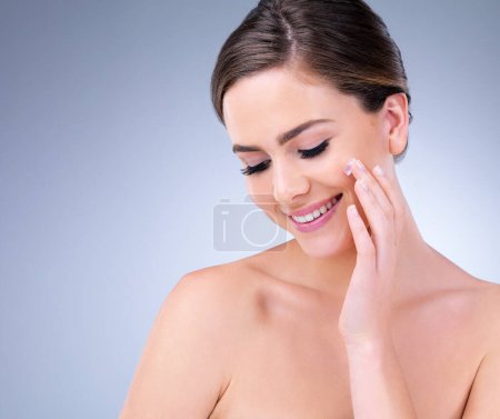 Photo for Skin first, makeup second, smile always. a young woman applying moisturizer to her face - Royalty Free Image