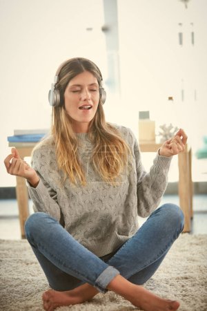 Téléchargez les photos : C'est ma façon de me détendre. une femme qui écoute de la musique tout en se relaxant à la maison - en image libre de droit