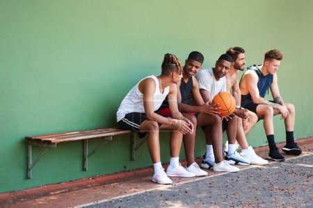 Foto de El baloncesto es lo que nos une. un grupo de jóvenes deportistas tomando un descanso después de un partido de baloncesto - Imagen libre de derechos