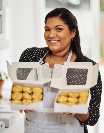 Photo for You know where to get your baked goods for all occasions. a woman showing off her freshly baked goods - Royalty Free Image