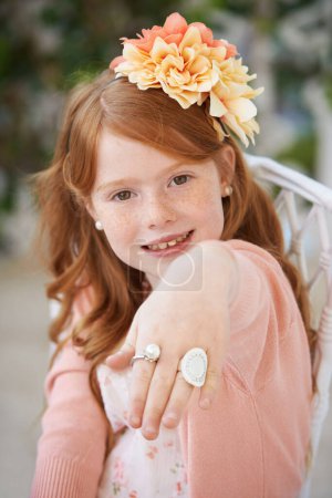 Photo for Little lady. A pretty red head girl showing off her costume jewlrey rings - Royalty Free Image