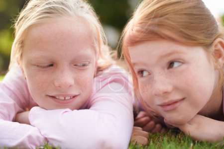 Téléchargez les photos : Meilleurs amis pour toujours. Deux petites filles allongées sur l'herbe - en image libre de droit