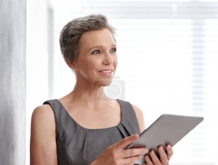 Photo for Touching the future of business. A mature businesswoman looking thoughtful while holding her tablet - Royalty Free Image