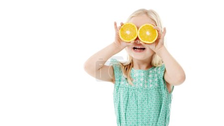 Photo for Fruity fun. Studio shot of a cute little girl playfully covering her eyes with oranges against a white background - Royalty Free Image