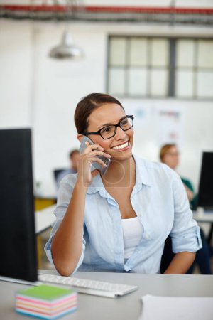 Foto de Otro cliente satisfecho. una joven diseñadora hablando por teléfono mientras está sentada en su escritorio - Imagen libre de derechos