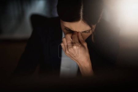 Photo for Headache, stressed businesswoman working late at night and overworked in a office. Burnout or mental health, anxiety and female worker in dark workplace tired or frustrated with hand by face - Royalty Free Image