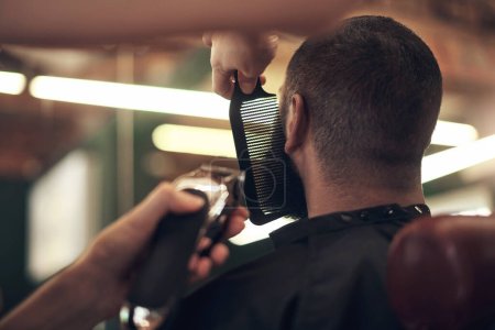 Téléchargez les photos : S'assurer que c'est parfait. une coiffeuse méconnaissable coiffant ses clients barbe dans son salon - en image libre de droit