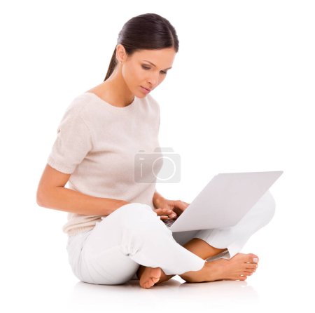Photo for Enjoying the freedom of wireless technology. A young woman sitting on the floor and working on her laptop - Royalty Free Image