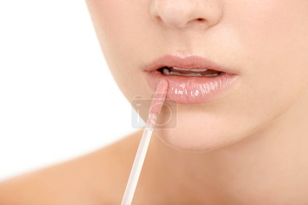 Photo for Making her soft lips even more luscious. Cropped closeup shot of a young woman applying lip gloss - Royalty Free Image