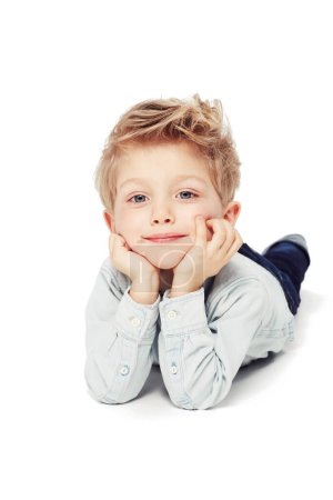 Photo for Portrait, smile and boy lying down, relax and cheerful kid isolated against white studio background. Face, male child or young person with happiness, casual and chilling with joy, happy and confident. - Royalty Free Image