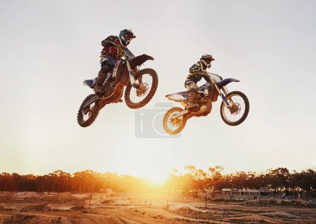 Foto de Moto, salto y aventura durante la carrera para la competencia como transporte con puesta de sol. Hombres, motocicleta y acción para deportes al aire libre en curso rápido con potencia y moviéndose rápido con riesgo - Imagen libre de derechos