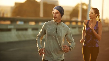 Téléchargez les photos : Profiter d'un jogging matinal. deux amis faisant du jogging sur une route tôt le matin - en image libre de droit