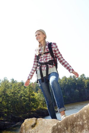 Téléchargez les photos : Sensation d'être stimulé par le plein air. Une jeune randonneuse debout au sommet d'une montagne et arpentant la vue tout en exprimant sa joie devant son accomplissement - en image libre de droit