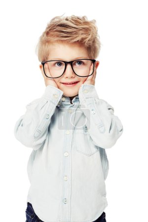 Foto de Lindo, pensativo y un niño pequeño con gafas y una sonrisa aislada sobre un fondo blanco. Feliz, idea y un niño de jardín de infantes con gafas de estudiante para la inteligencia y la moda en un fondo de estudio. - Imagen libre de derechos