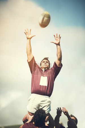 Téléchargez les photos : Redémarrage du jeu. un jeune joueur de rugby attrapant la balle lors d'une sortie de ligne - en image libre de droit