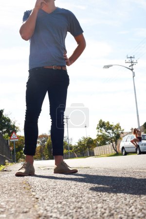 Photo for Hipster styling. Cropped view of a young hipster guy standing in the street with his girlfriend sitting in the distance behind him - Royalty Free Image