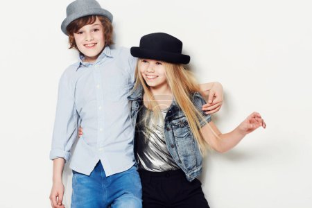 Photo for Fashion, kids or happy with a brother and sister in studio isolated on a white background for contemporary style. Smile, hat and children with best friends posing in fashionable or stylish clothes. - Royalty Free Image