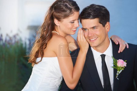 Foto de Sólo tú y yo. Una hermosa novia susurrando a su guapo novio el día de su boda - Imagen libre de derechos