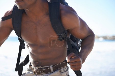 Foto de Músculos y resistencia. Un hombre afroamericano musculoso corriendo por la playa - Imagen libre de derechos