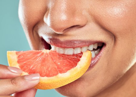 Photo for Citrus is wonderful for brightening. a woman biting into a slice of grapefruit against a studio background - Royalty Free Image