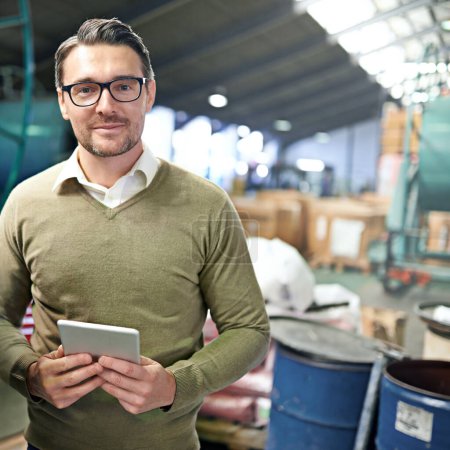 Photo for Digital warehouse organization. a man holding a digital tablet in a warehouse - Royalty Free Image
