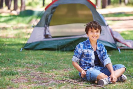 Téléchargez les photos : Il revendique son emplacement de camping. Un garçon debout devant son camping - en image libre de droit