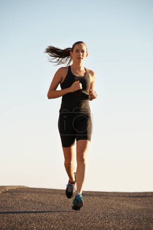Foto de Corriendo rápido y libre. una joven corriendo por un camino - Imagen libre de derechos