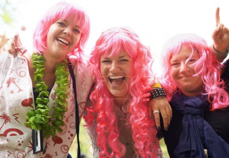 Téléchargez les photos : La brigade rose est arrivée. Trois amis s'amusent à un festival - en image libre de droit