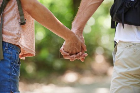 Téléchargez les photos : Aucune route n'est trop longue quand nous sommes ensemble. un couple affectueux se tenant la main tout en marchant dans la forêt - en image libre de droit