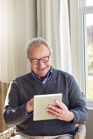 Foto de El hogar es donde el wifi se conecta automáticamente. un hombre mayor usando una tableta en casa - Imagen libre de derechos