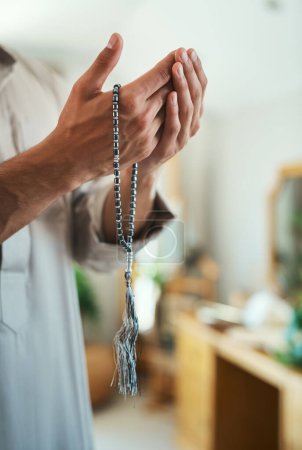 Téléchargez les photos : Le désir de prier est une prière en soi. un musulman méconnaissable priant dans le salon à la maison - en image libre de droit