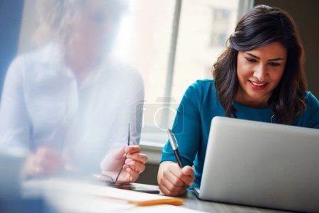 Photo for Productive employees doing what they do best. two businesswomen using a laptop together in an office - Royalty Free Image