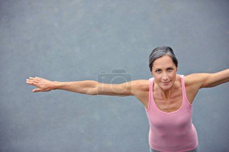 Téléchargez les photos : Le yoga me garde en forme. Portrait grand angle d'une jolie femme mature qui fait du yoga à l'extérieur - en image libre de droit