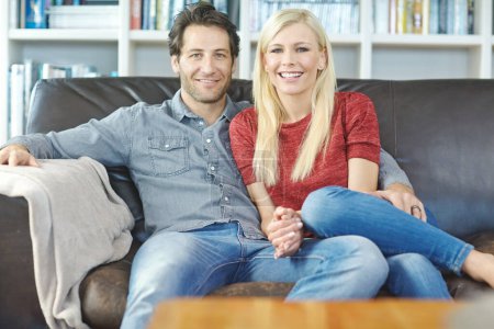 Photo for Enjoying eachothers company. Portrait of a young couple sitting on a couch together - Royalty Free Image