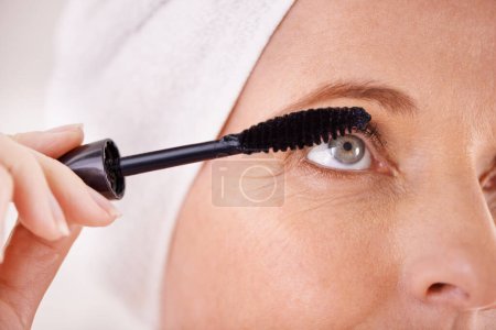 Foto de Sacando sus hermosos ojos. Primer plano de una mujer madura aplicando rímel - Imagen libre de derechos