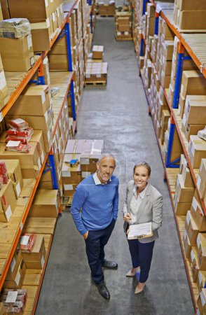 Foto de Este almacén está tan organizado como puede ser. Retrato de dos gerentes mirando el stock en un almacén grande - Imagen libre de derechos