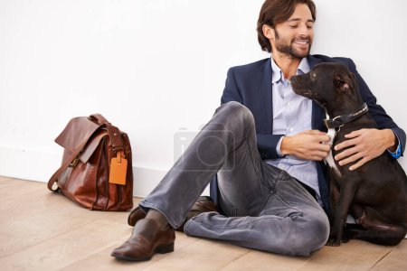 Photo for Hes my best friend. A handsome businessman sitting next to his loyal dog - Royalty Free Image