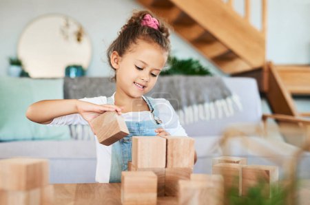 Foto de Voy a apilarlos uno por uno. Retrato de una adorable niña jugando con bloques de madera en casa - Imagen libre de derechos