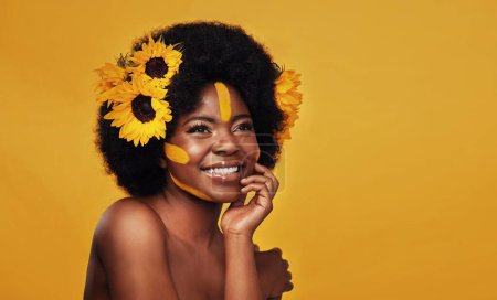 Téléchargez les photos : Tournesol, beauté et femme noire heureuse en studio pour le maquillage, le bien-être et le traitement sur fond jaune. Fleur, soins de la peau et modèle féminin africain sourire, se détendre et poser avec des cosmétiques naturels de la peau. - en image libre de droit