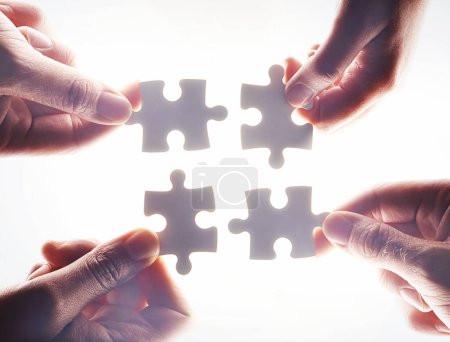 Photo for Hands, puzzle and flare with a business team working together on project planning closeup from below. Teamwork, collaboration or synergy and employee group with a jigsaw for strategy or innovation. - Royalty Free Image