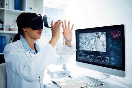 Téléchargez les photos : Quand les soins de santé gagnent, on gagne tous. un scientifique utilisant un casque de réalité virtuelle lorsqu'il effectue des recherches dans un laboratoire - en image libre de droit