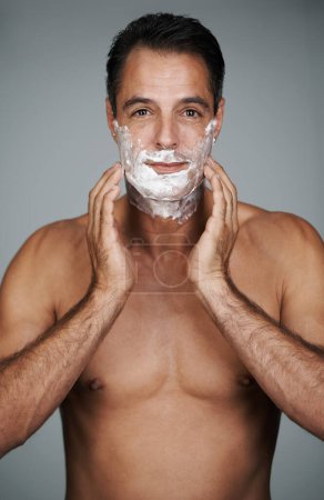 Photo for Ready for a close shave. Studio portrait of a handsome mature man applying shaving cream to his face - Royalty Free Image