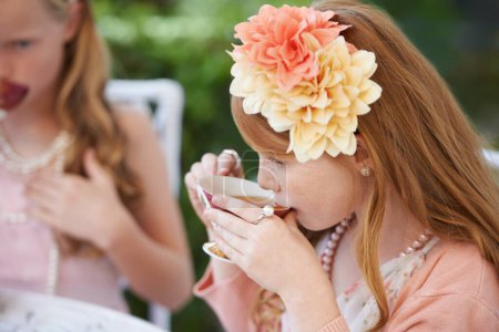 Téléchargez les photos : Je prends une gorgée de thé. Deux jeunes filles faisant une partie de thé dans le jardin - en image libre de droit