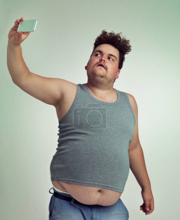 Foto de Este es el mejor ángulo. un hombre con sobrepeso tomando una selfie desde un ángulo alto - Imagen libre de derechos
