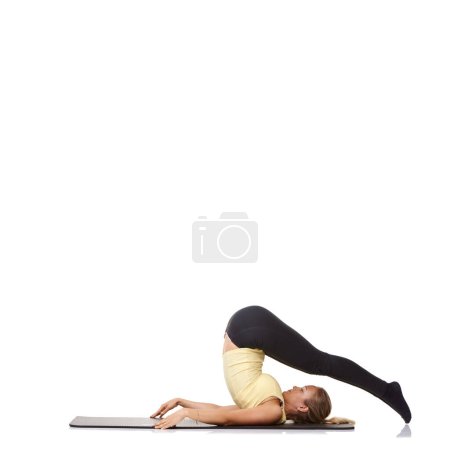 Foto de Flexibilidad y fitness. Una joven en forma acostada sobre su espalda y estirando sus piernas sobre su cabeza - haciendo ejercicio - Imagen libre de derechos