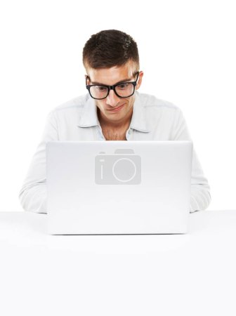 Téléchargez les photos : Voyons ce que le World Wide Web a à offrir. Un homme assis à son bureau travaillant sur son ordinateur portable avec des lunettes hipster sur - en image libre de droit